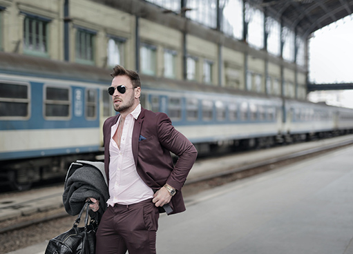 podróż - mężczyzna z walizką czekający na pociąg
